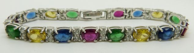 A white metal tennis bracelet set with oval blue paste and synthetic rubies, marked 18k, 12.8g