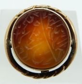 A yellow metal ring marked 14k set with engraved carnelian agate, 8.2g, size K/L