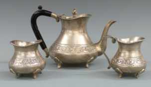 Indian white metal three piece teaset with embossed decoration, marked silver to bases, height of