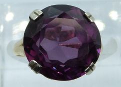 An 18ct gold ring set with a round cut synthetic purple sapphire, 4.3g, size I