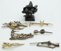 A silver figure of a Ekeko god, two silver shooting brooches and other brooches