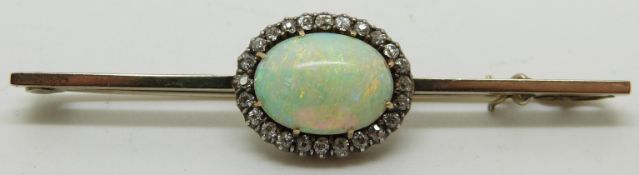 A 9ct gold brooch set with an opal cabochon of approximatey 2.5ct surrounded by diamonds, length