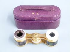 A pair of Asprey opera glasses in original fitted leather box, the gilt glasses set with black and