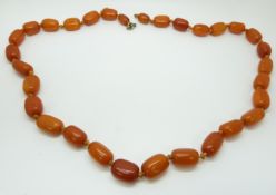 A Baltic amber beaded necklace made up of 30 barrel shaped beads, 41g