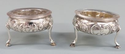 Pair of Georgian hallmarked silver open salts with embossed decoration and raised on three feet,