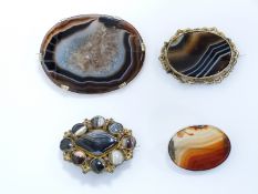 A large Victorian brooch set with a panel of agate, two pinchbeck brooches set with agate and a