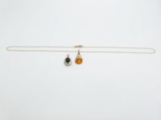 A 9ct gold pendant set with pressed amber and a 9ct gold pendant set with a sapphire, 4g