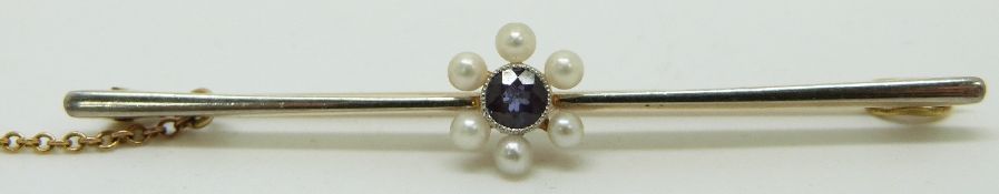A 15ct bar brooch with platinum finish set with a sapphire surrounded by seed pearls, 5.5cm