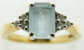 An 18ct gold ring set with an emerald cut aquamarine and diamonds, 3.9g, size N
