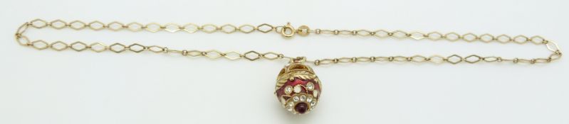 A 9ct gold chain with a silver gilt enamel egg pendant, 3.2g