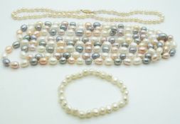 A long cultured pearl necklace made up of pink, grey and white pearls, another cultured pearl