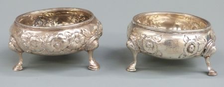 Pair of Victorian hallmarked silver open salts with embossed decoration raised on three hoof feet,