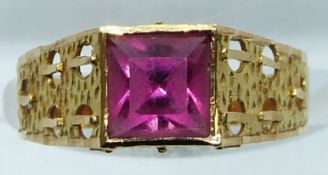 A yellow metal ring set with a square cut paste stone, 2g, size M