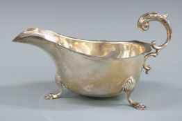 George V hallmarked silver sauce boat with shaped edge and raised on three pad feet, Birmingham 1931