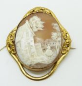 Victorian pinchbeck brooch set with a cameo depicting a lady in a village setting, 5.8 x 4.5cm