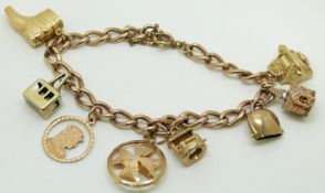 A 9ct gold charm bracelet with seven 9ct gold charms including telephone, church, etc, 30.8g