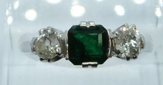 An 18ct white gold ring set with an emerald cut emerald of approximately 0.8ct and two diamonds,