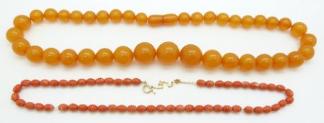 A carved coral necklace threaded on a 9ct gold chain and an amber style necklace