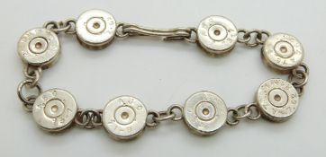 A silver bracelet made up of links in the form of shotgun cartridges/ bullets
