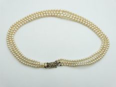 A three strand pearl necklace with 9ct white gold clasp set with a diamond