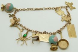 A 9ct gold charm bracelet with twelve 9ct gold charms including spider, dog, globes, etc, 11.3g