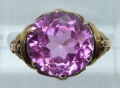 A 14k gold ring set with a round cut synthetic pink sapphire, 3.7g, size K/L