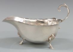 George V hallmarked silver sauce boat with shaped edge and raised on three pad feet, Chester 1930