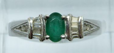 A 14ct white gold ring set with an oval cut emerald, round and baguette cut diamonds, 3.7g, size N/