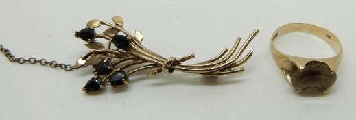 A 9ct gold ring set with a smoky quartz and a 9ct gold brooch set with sapphires, 5.4g