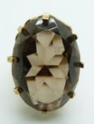 A 9ct gold ring set with an oval smoky quartz, 10.8g, size M