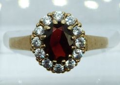 A 9ct gold ring set with a garnet and cubic zirconia, 2.1g, size K/L