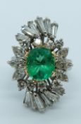 A platinum ring set with an oval cut natural Colombian emerald of approximately 3ct surrounded by