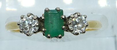 An 18ct gold ring set with an emerald of approximately 0.35ct and two diamonds each approximately