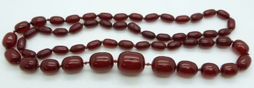 A cherry amber necklace made up of 55 graduated oval beads, largest 26x22mm, 95g.