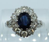 An 18ct white gold ring set with an oval cut sapphire of approximately 1.5ct surrounded by