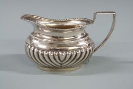 Victorian hallmarked silver bachelor's cream or milk jug with gadrooned edge and lobed lower body,