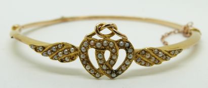 Victorian bangle set with seed pearls in the form of two knotted hearts and wings, 6.1g