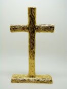 A yellow metal free standing cross with textured bark decoration, various impressed marks including