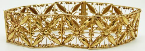 A yellow metal bracelet of square links with filigree and faceted flower decoration, 30.7g