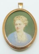 A yellow metal pendant set with a portrait miniature of a young woman, in original box