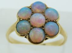An 18ct gold ring set with seven round opal cabochons in a cluster, 3.8g, size O