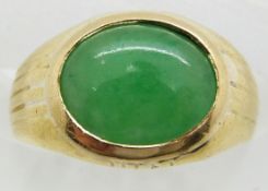 A yellow metal ring set with a jadeite cabochon, 4.2g, size D/E