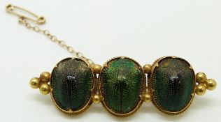 Victorian yellow metal brooch set with three scarab beetles, 4.6cm