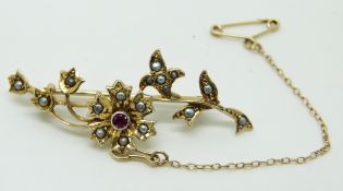 Edwardian brooch set with a ruby and seed pearls in a floral design, 3.5g