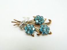 A 9ct gold bi-coloured brooch set with three clusters of zircons and diamonds, in a Garrard & Co