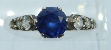 An 18ct gold ring set with a synthetic sapphire and paste, 2g, size P