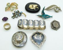 A collection of brooches including a jet example with ivory detail, silver, Siam silver and Thai