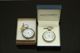 Two silver ladies open faced pocket watches both with black Roman numerals, floral decorated white