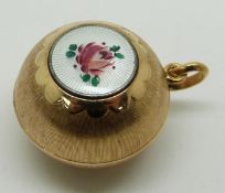 A yellow metal spherical pendant with a guilloché enamel cartouche decorated with a rose, diameter