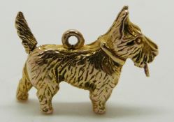 A 9ct gold charm/ pendant in the form of a dog with movable tail which moves a red enamel tongue,